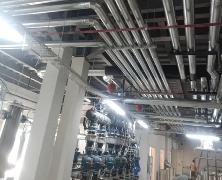 Mekanik tesisat hacminde yalıtımlı boru hatları, pompa grubu ve tavan boyunca uzanan kanal güzergâhı.